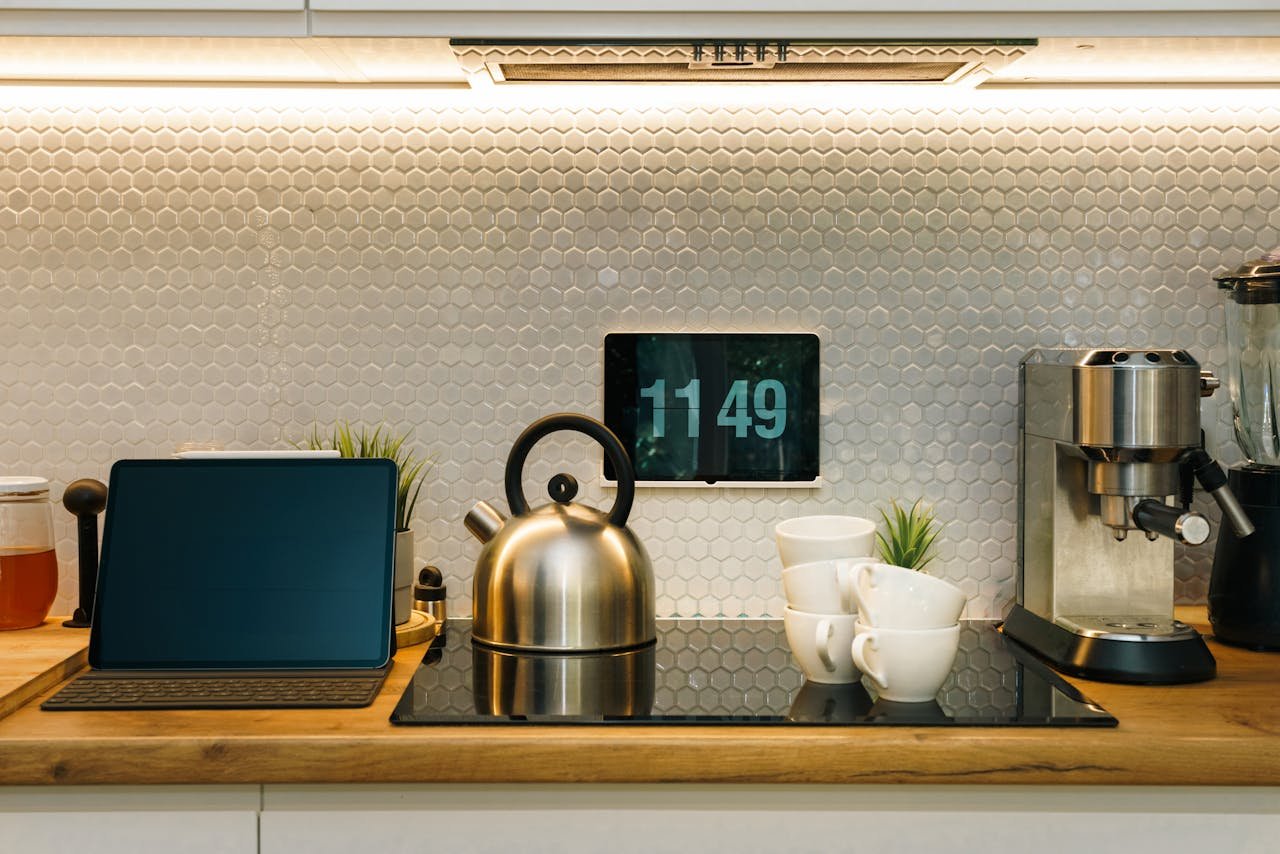 A stylish kitchen with smart devices, coffee machine, and digital clock on counter.